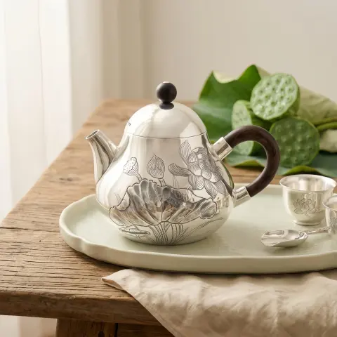 إبريق شاي فضي أنيق من الفضة الإسترلينية عيار 925 منقوش يدويًا يتميز بتصميم زهرة اللوتس المعقد ومقبض من الخشب الطبيعي - صناعة يدوية